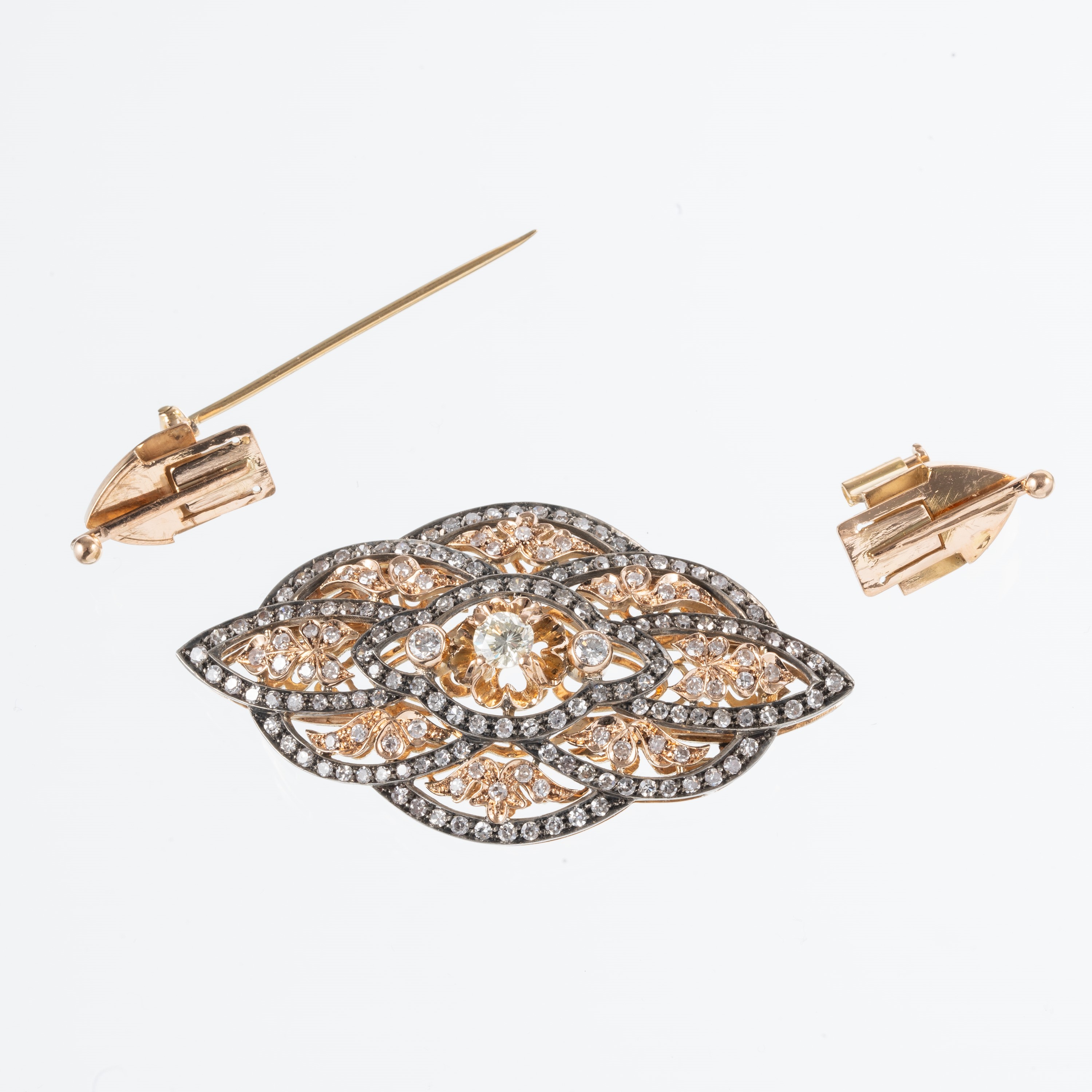 Spilla trasformabile in pendente, oro rosso 18 kt e argento brunito, diamante centrale e contorno...