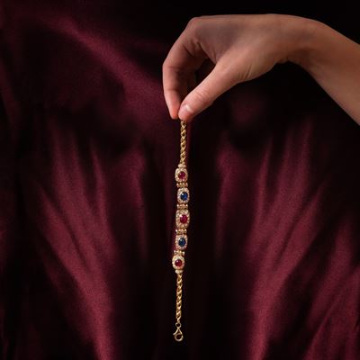 Bracciale in oro giallo 18 kt con zaffiri, rubini cabochon e diamanti taglio brillante
