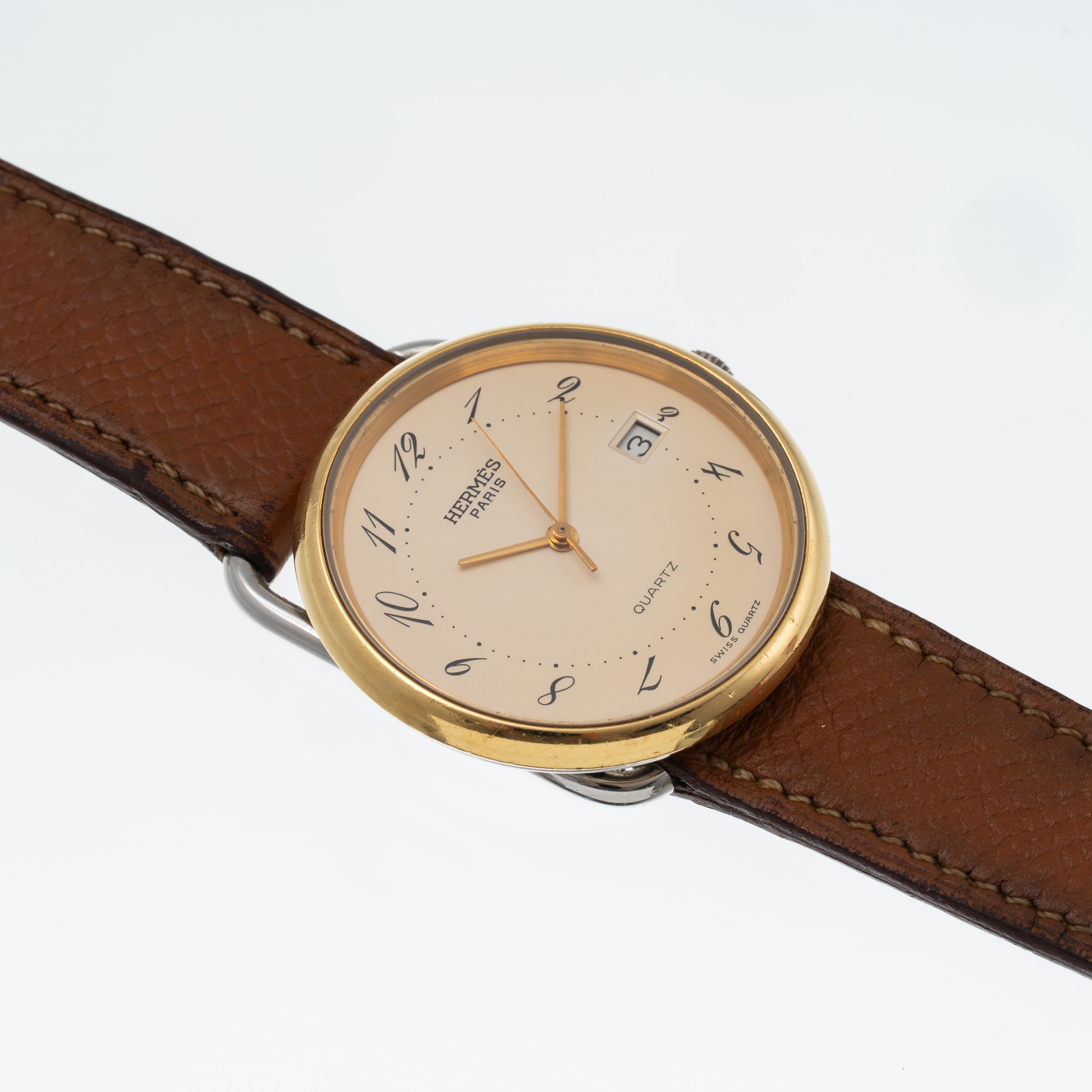 Hermès - Orologio Solo Tempo al quarzo in acciaio con quadrante champagne, ghiera dorata e datari...