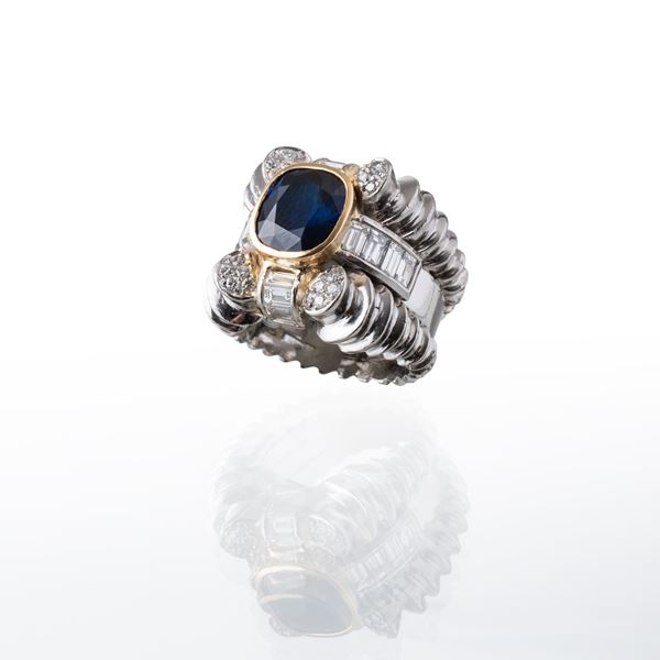 ANELLO IN PLATINO CON ZAFFIRO CENTRALE E DIAMANTI TAGLIO BRILLANTE E BAGUETTE