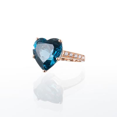 Anello in oro rosa 18 kt con topazio blu, taglio a cuore e dieci brillanti (ct 0,20 ca.)