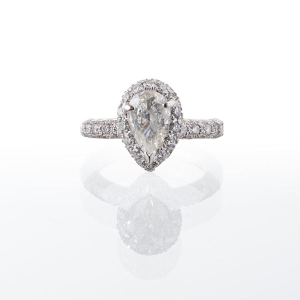 ANELLO IN ORO BIANCO 18 KT CON DIAMANTE A GOCCIA E CONTORNO DI BRILLANTI