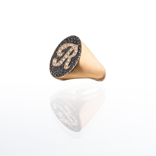 ANELLO IN ORO 18 KT CON DIAMANTI TAGLIO BRILLANTE E ONICE, LETTERA "R"