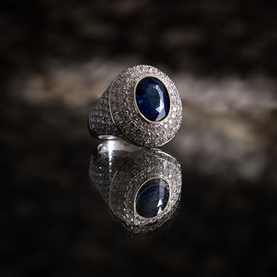 Anello in oro bianco 18 kt, pavé di diamanti e zaffiro centrale (ct diamanti 5,52; ct zaffiro 7,0...