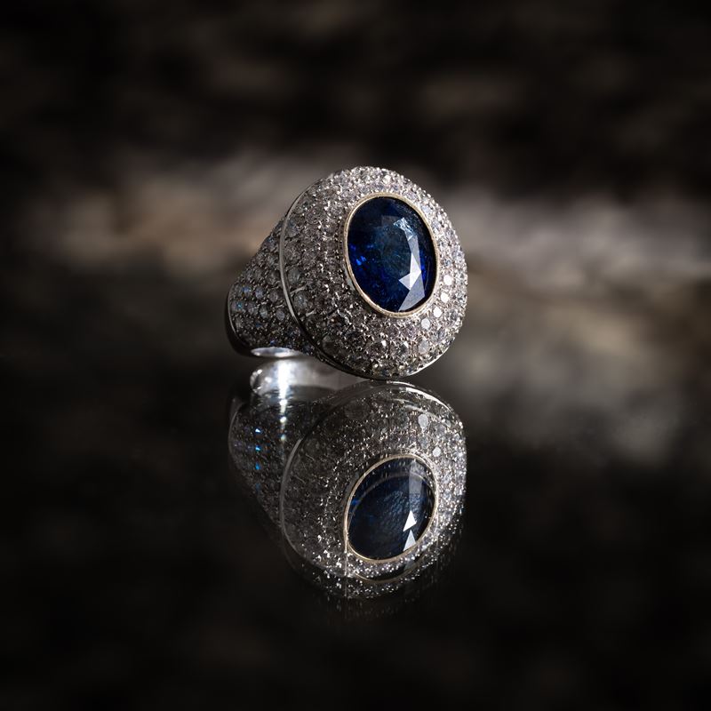 Anello in oro bianco 18 kt, pavé di diamanti e zaffiro centrale (ct diamanti 5,52; ct zaffiro 7,0...