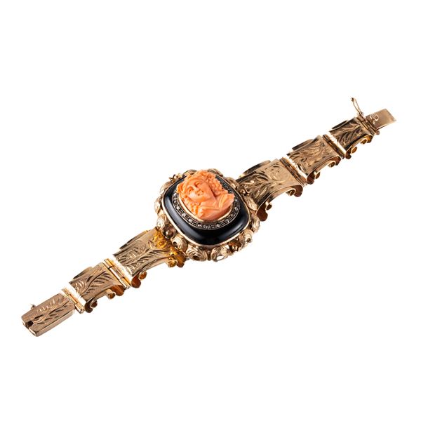 BRACCIALE IN ORO GIALLO 14KT CON VOLTO IN CORALLO INCISO E ONICE